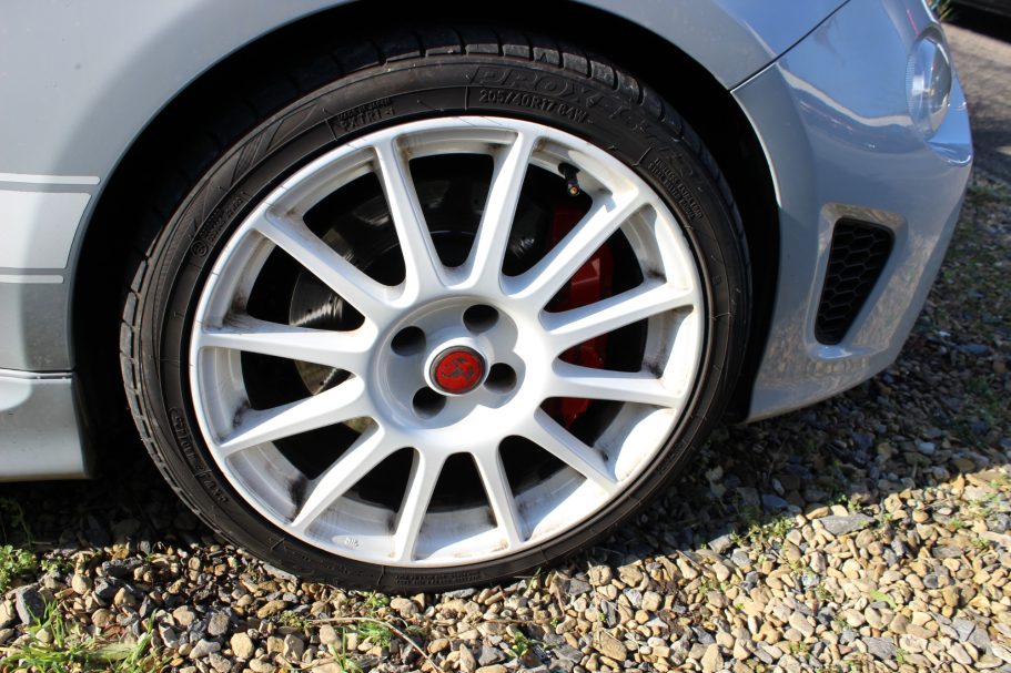 Close-up of a silver car wheel with a multi-spoke design and red brake caliper.