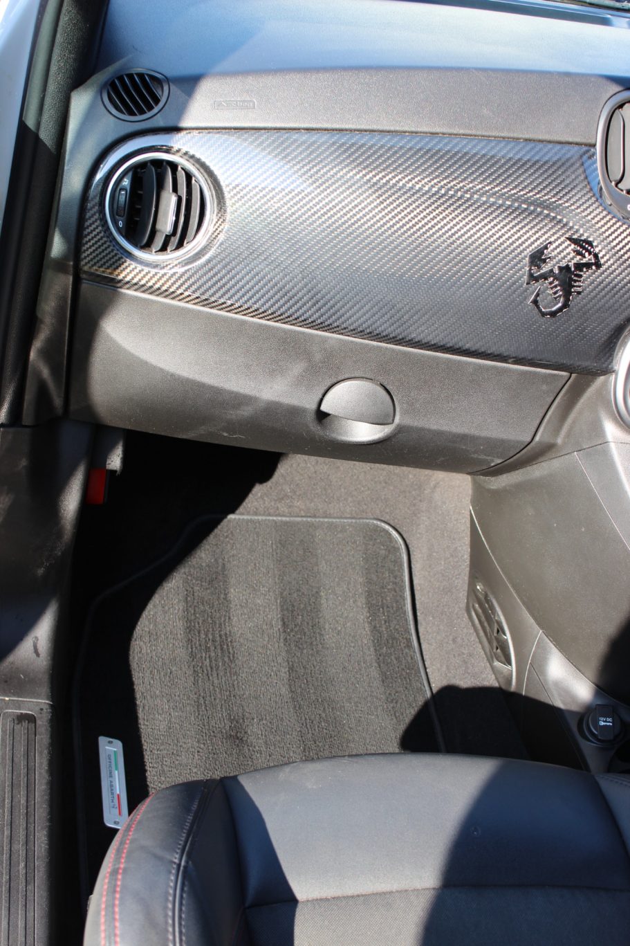 Interior view of a car's door panel and floor mat.
